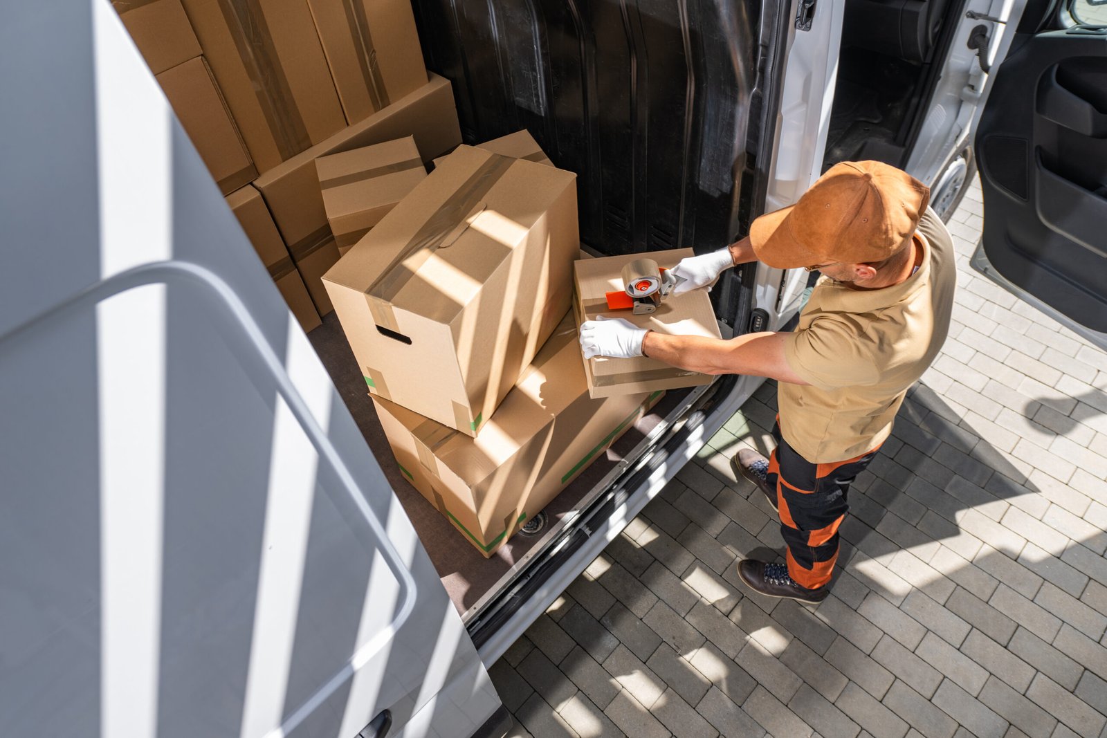 Mitarbeiter von MK Transport tragen Umzugskartons zum Transporter