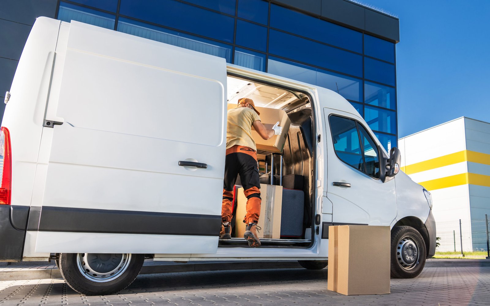 Mitarbeiter belädt einen Transporter mit Umzugskartons
